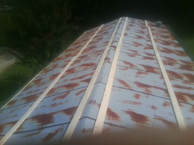 Rusted metal roof panels with new wood purlins before replacement — Storm Damage Roof Repair in Ace by Roofing Brothers